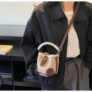 Détail du sac seau en laine d'agneau avec base en cuir contrastée et bandoulière