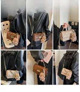 Close-up of quilted crossbody bag with chain strap and cute plush bear charm detail