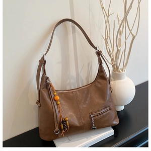 Détail du sac cabas marron vintage avec pendentif ethnique et texture en similicuir souple