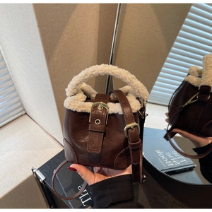 Détail d'un mini sac seau en similicuir marron avec bordure en peluche blanche
