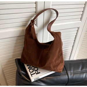 Detailed close-up of dark brown suede tote bag texture and high-quality stitching
