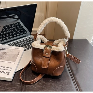 Détail du sac seau vintage en cuir marron avec bordure en fausse fourrure blanche