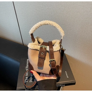 Détail de la garniture en peluche sur un sac seau vintage en cuir beige et marron