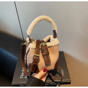 Détail du sac seau vintage en cuir marron avec garniture en peluche et poignée supérieure