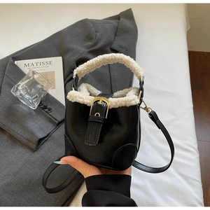 Détail du mini sac seau en cuir noir brillant avec bordure en fausse fourrure blanche