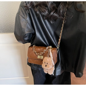 Brown quilted crossbody bag featuring a gold clasp and cute plush bear charm detail