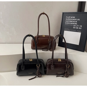 Sacs à main chic en cuir noir et marron disposés sur des marches blanches minimalistes