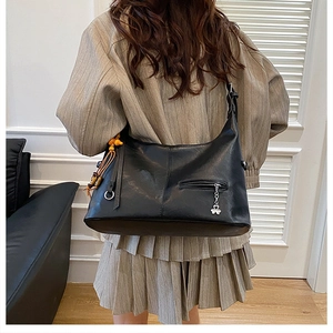 Détail du grand sac cabas en similicuir noir avec fermeture éclair fleurie et perles