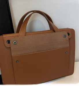 Dettaglio borsa tote marrone con patta scamosciata e borchie in metallo nero