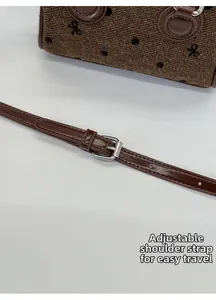 Detail of adjustable leather strap and silver buckle on the brown textured bowling bag