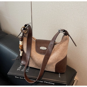 Detail of retro suede dumpling bag with fashion metal plate and decorative beads