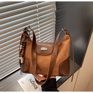 Close-up of retro brown patchwork dumpling bag with wooden beads and silver metal buckle