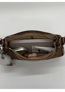 Top view of brown baguette bag interior with silver zipper showing daily essentials capacity