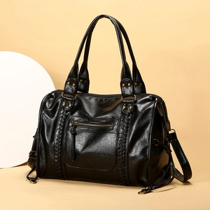 Dettaglio borsa tote vintage nera con trecce e borchie in bronzo su ecopelle