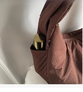 Detail view of the durable dark brown fabric bag showing its side storage pocket