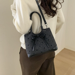 Polka dot tweed tote bag with bow detail shown worn as a crossbody by model