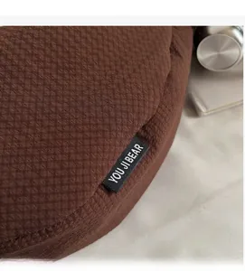 Close-up of the dark brown checkered fabric texture with a YOU JI BEAR brand label