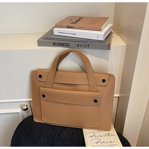 Dettaglio della borsa business in pelle color cuoio con manici e tasca a pressione