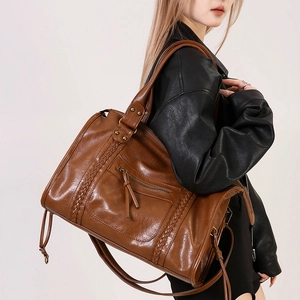 Borsa tote vintage marrone con strisce intrecciate e tracolla indossata da modella