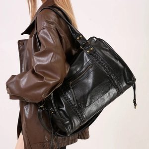 Dettaglio della borsa tote vintage nera con finiture intrecciate e metalli in bronzo