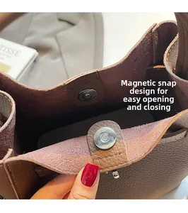 Close-up of silver magnetic clasp on brown lychee grain leather bucket bag