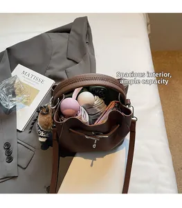 Detail view of brown leather bucket bag interior showing high capacity for daily items