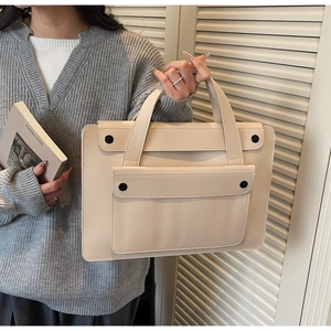 Dettaglio della borsa beige in ecopelle con cuciture fini e bottoni neri decorativi
