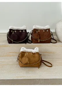 Détail de sacs seaux mats avec bordure en fausse fourrure, embossage et chaîne dorée