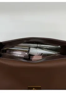 Vue de dessus du compartiment intérieur spacieux du sac bandoulière en cuir marron foncé