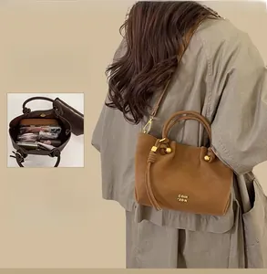Detail of vintage brown bucket bag showing sub-bag design and adjustable shoulder strap