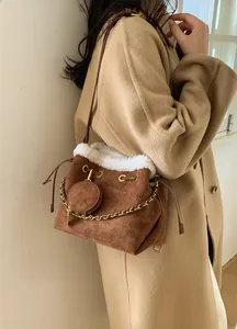 Détail du sac seau marron vintage mat avec bordure en fausse fourrure et chaîne dorée