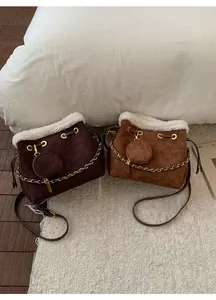 Détail des sacs seau en daim avec bordure en fausse fourrure et gaufrage floral