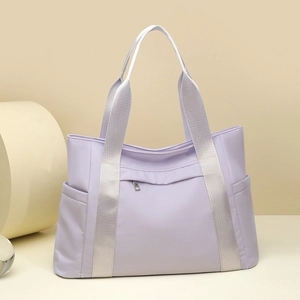 Detailed view of light purple nylon tote bag with reinforced grey straps and side pockets