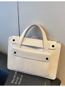 Borsa porta PC minimalista bianco crema con tasca frontale su sfondo muro grigio