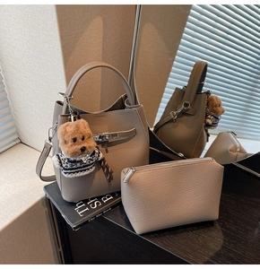 Detail of grey lychee leather bucket bag with silver buckle and teddy dog charm