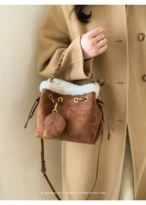 Détail du sac seau en daim marron avec bordure en fausse fourrure et motif gaufré