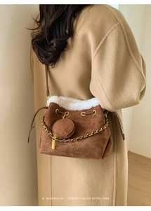 Détail du sac seau en daim marron avec garniture en peluche blanche et chaîne dorée