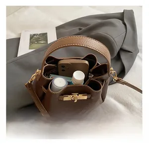 Interior view of brown pebble leather bucket bag showing capacity for phone and cosmetics