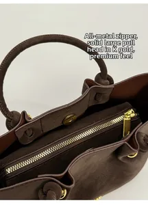 Detail of high-quality gold-tone metal zipper and textured suede leather of bucket bag