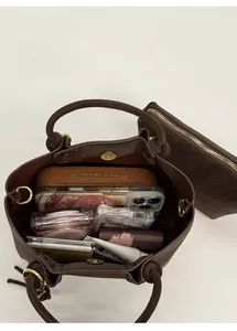 Detail view of large capacity interior for brown bucket bag with matching small pouch