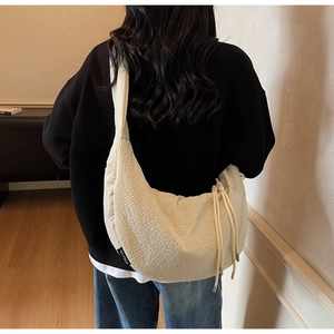 Close-up of beige dumpling bag featuring unique waffle texture fabric and drawstring detail