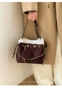 Détail du sac seau en daim marron avec garniture en fausse fourrure et gaufrage