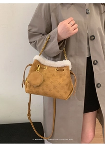 Sac seau rétro marron avec bordure en fausse fourrure blanche et chaîne dorée sur mannequin