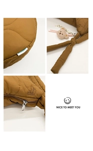 Détails d'un sac bandoulière matelassé marron avec pendentif ours et fermeture éclair