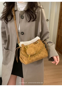 Sac seau en cuir givré marron avec bordure en fourrure et chaîne sur trench-coat décontracté