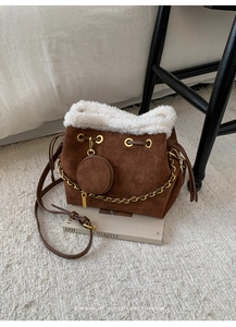 Détail d'un sac seau en daim marron avec bordure en fausse fourrure et motifs étoiles