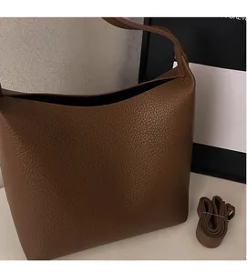 Detail of dark brown lychee leather handbag with adjustable matching shoulder strap