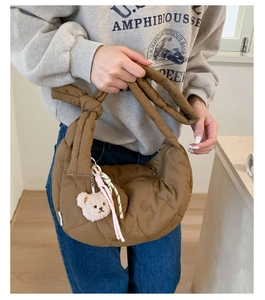 Sac croissant marron à matelassage cœur avec bandoulière nouée et breloque ours