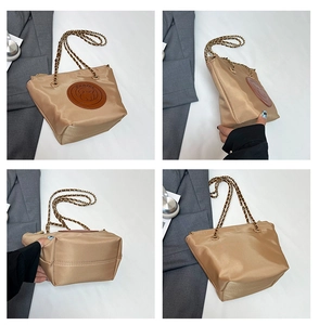 Vue détaillée du sac seau en nylon kaki avec chaîne dorée et patch en cuir animal