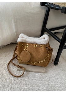 Détail du sac seau marron en fausse fourrure avec motifs gaufrés et chaîne dorée